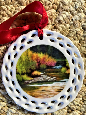 Round Ceramic Ornament " Autumn Stream " Meandering Mountain stream with green and red early fall bushes  3.5 " round  Red Ribbon for display or hanging  Decorative border