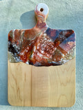 Artisan Maple Cheese Board / Handle Artist: Marcy Knotwell  Copper Penny, Brown, White and Liquid Gold Lacing resin design  You will not be disappointed with the quality of this product! Our handcrafted wood grained-edge charcuterie cheese boards are the answer to stylish, multi-functional, sustainable serve-ware.