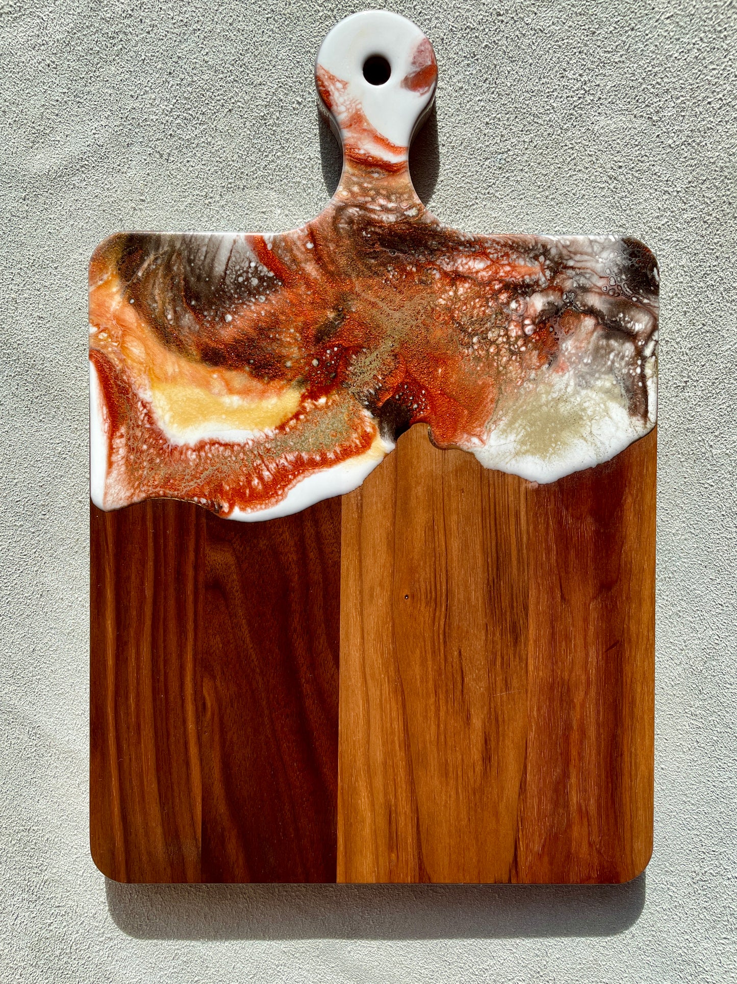Walnut Artisan Cheese Board / Handle Artist: Marcy Knotwell  Copper penny, white, brown and liquid gold lacing resin design  You will not be disappointed with the quality of this product! Our handcrafted wood grained-edge charcuterie cheese boards are the answer to stylish, multi-functional, sustainable serve-ware.  When not in use, this charcuterie cheese board makes a beautiful addition to your countertop or gallery wall.
