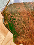 Artisan Rounded Cheese Board / Handle Artist: Marcy Knotwell  Copper Penny, Olive green, and brown resin design  You will not be disappointed with the quality of this product! Our handcrafted wood grained-edge charcuterie cheese boards are the answer to stylish, multi-functional, sustainable serve-ware.  When not in use, this charcuterie cheese board makes a beautiful addition to your countertop or gallery wall.