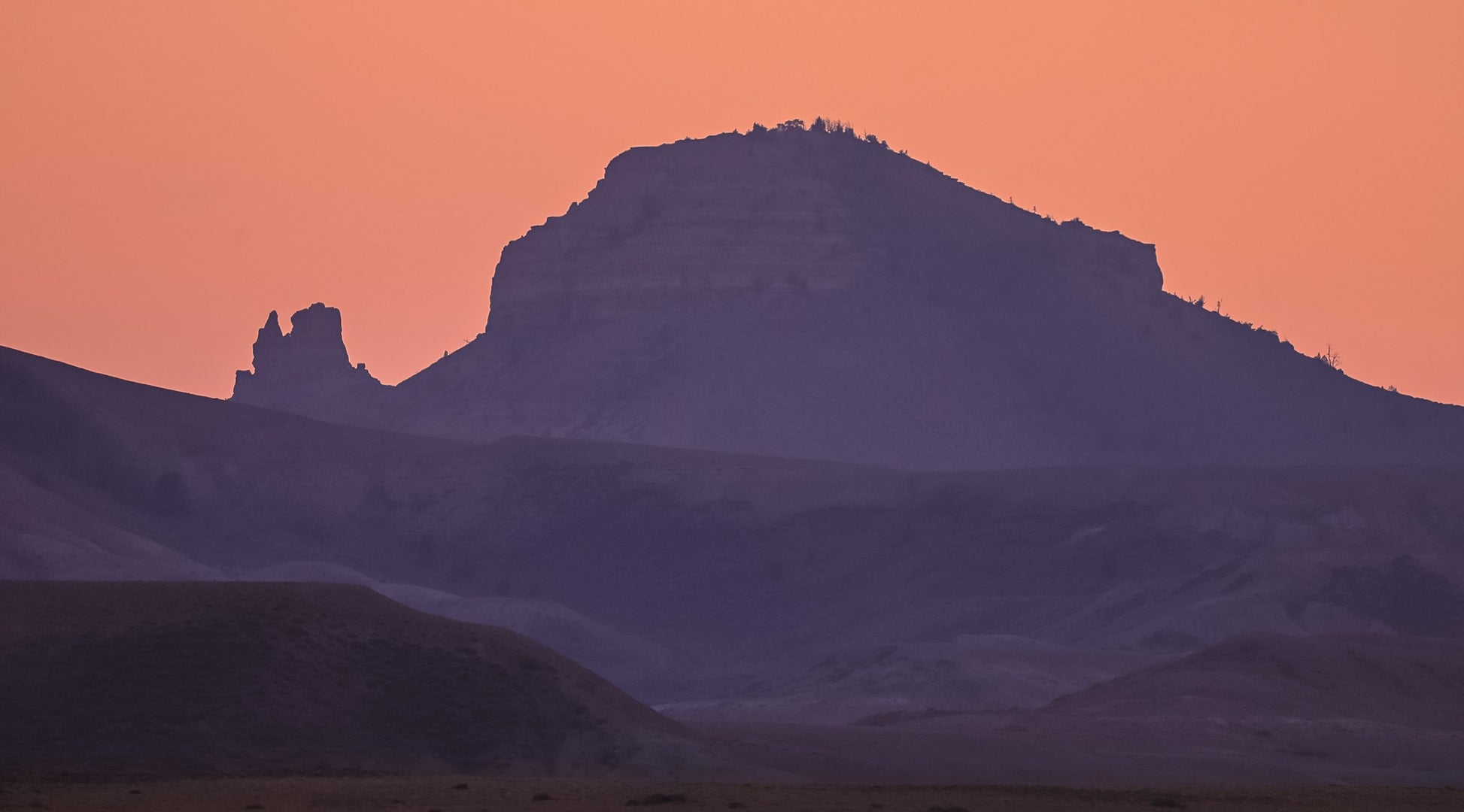 Sunset photography of the Oregon Buttes Oregon Buttes, Red Desert Jason Sondgeroth, Artist  Photograph  Red Desert, Wyoming  Oregon Buttes Sunset  12" X 8"  Cardstock for support  Clear, plastic sleeve for protection  Oregon Buttes: Wyoming’s northern red desert for the California, Oregon and Mormon Pioneer Trails and Pony Express  The pitted sandstone outcrops along the rim, along with twisted juniper trees and dense sagebrush, attract mule deer and resident desert elk