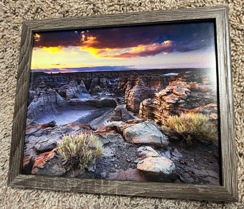 Adobe Town Sunset framed photography by Wyoming photographer, Kyle Spradley. Beautiful  sunset colors over a rocky and sagebrush landscape. Framed in a  rustic styled wood frame with an easel back for  free standing display.