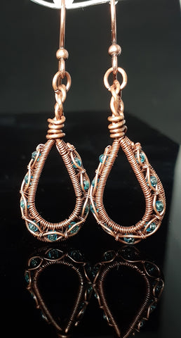 copper wire in a tear drop shape wrapping light blue glass beads