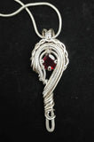 beautifully wrapped garnet in sterling silver wire necklace. 16 inch sterling silver chain
