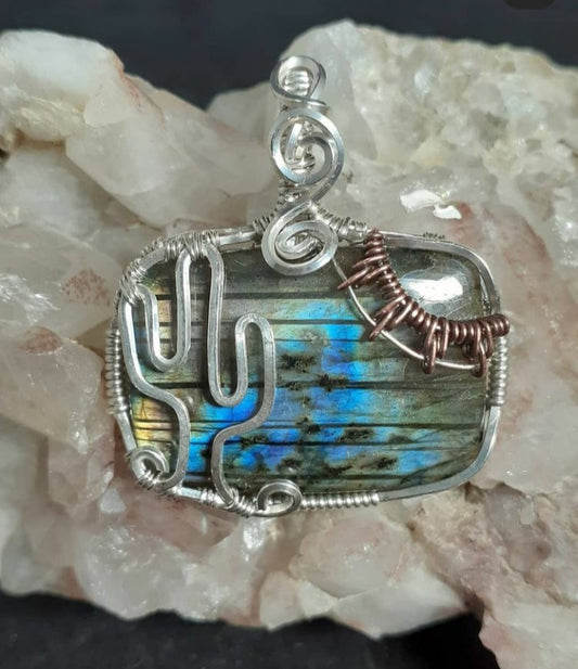 Sterling silver wrapped labradorite with cactus shape. Oxidized copper wire wrap makes a sun in the corner.