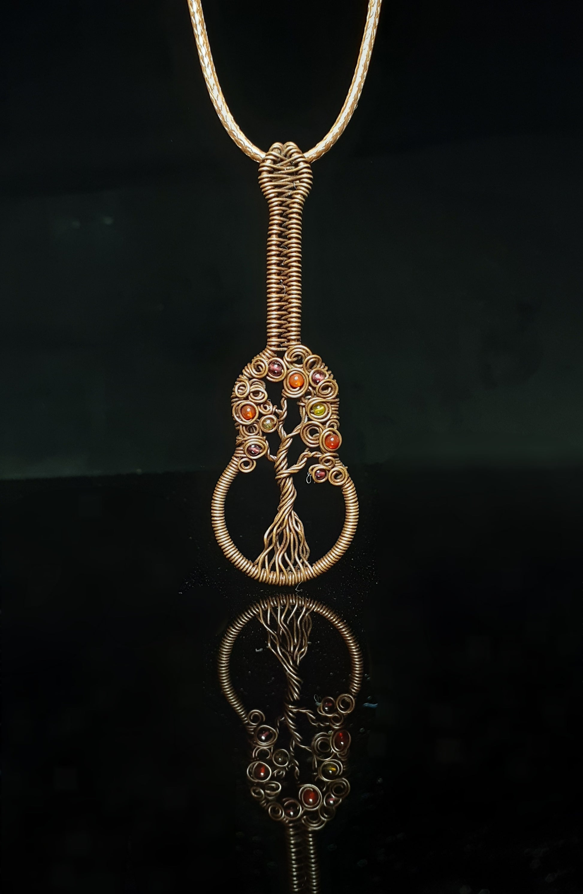 Agate beads in Autumn colors wrapped in oxidized copper   Guitar shaped with wrapped wire and fall colored agate beads.  Leather cord to wear as a necklace