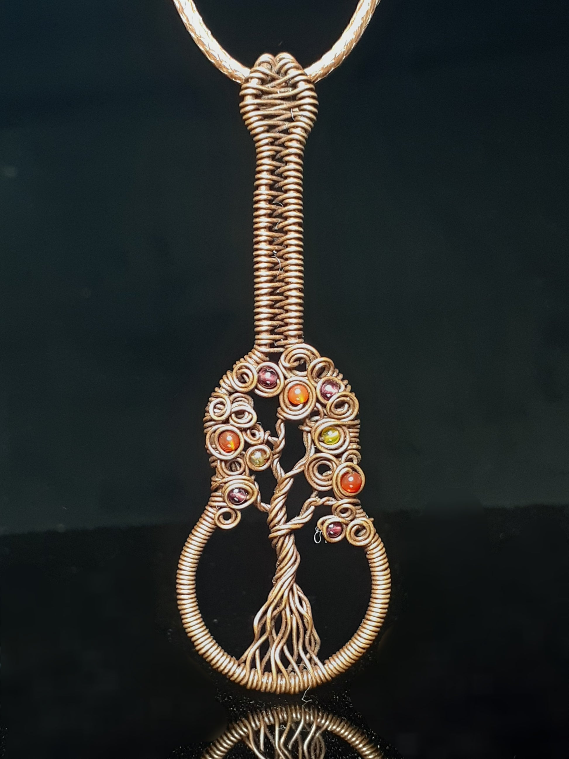 Autumn Colored Tree Of Life Guitar Pendent Artist: Lindsey Griffin Agate beads in Autumn colors wrapped in oxidized copper  Leather cord to wear as a necklace  2 7/8" Long x 1" Wide x 1/4" Deep  Care instructions and polishing cloth included  A beautiful delicate necklace for everyday use