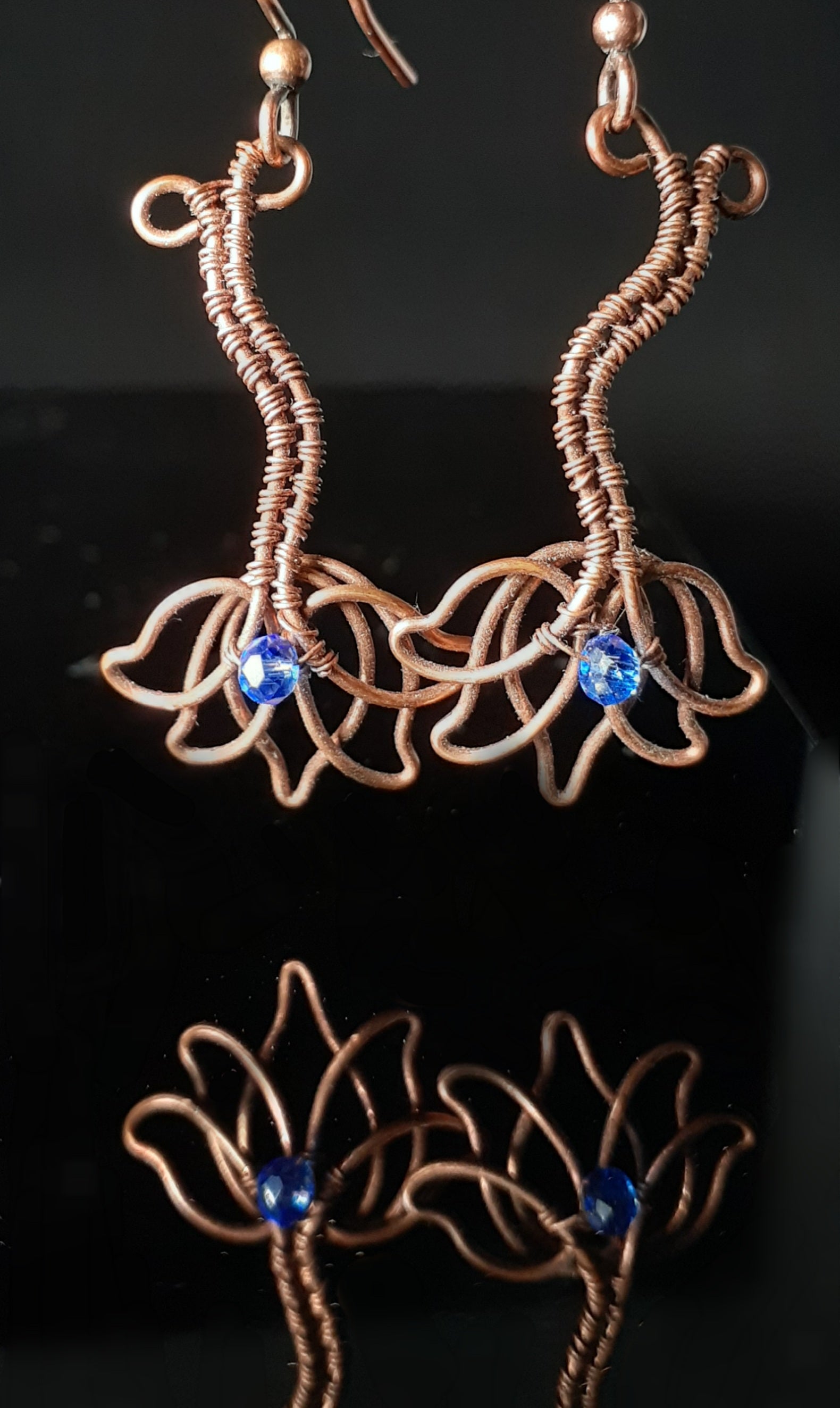 copper wire shaped like a Lotus Flower with a blue Swarovski crystal. hypoallergenic ear wires