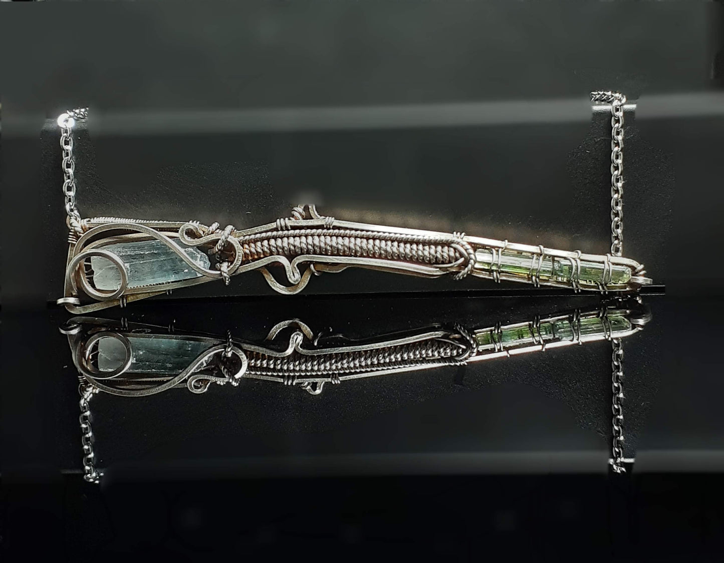 Blue Barite Green Tourmaline Shotgun Pendant Artist: Lindsey Griffin  Blue Barite from the Rocky Mountains wrapped to make up the stock of the shotgun