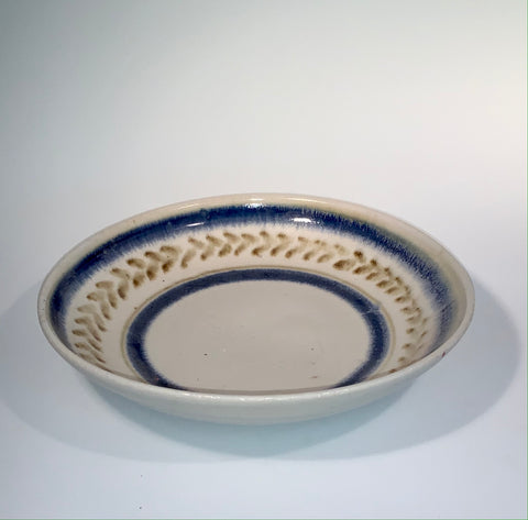 wide and shallow stoneware bowl. would work great for serving noodles. cobalt blue stripes with green decoration on white glaze.