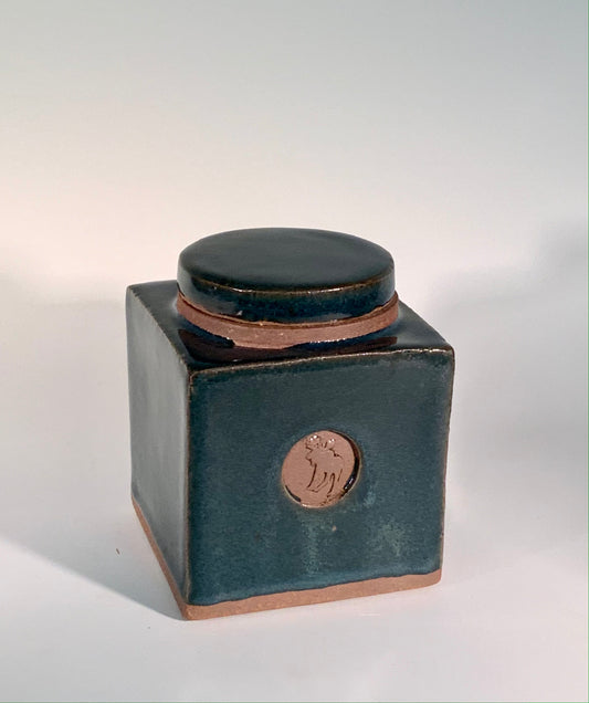 square stoneware jar with lid. Turquoise glaze. One moose stamp on the side