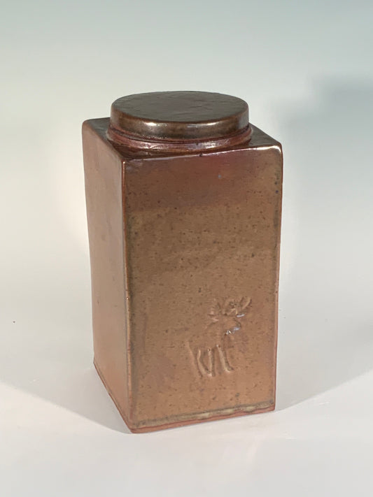 Tall Stoneware Jar Muffy Moore: Ceramic Potter Rectangle slab stoneware jar with lid  3 1/2" Long x 3 1/2" Wide x  7" High  Brown glaze  Moose stamp on one side  Large round opening with lid  Find the hidden stamp  Dishwasher safe, oven and food safe  Would make a nice storage container for dry goods