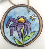 " Bumble Bee " Hand Painted Wooden Ornament Artist: Nancy Marlatt.  Whimsical Purple Flower ( Could be a daisy or cosmos)  Bumble Bee headed for nectar  Blue and white sky background