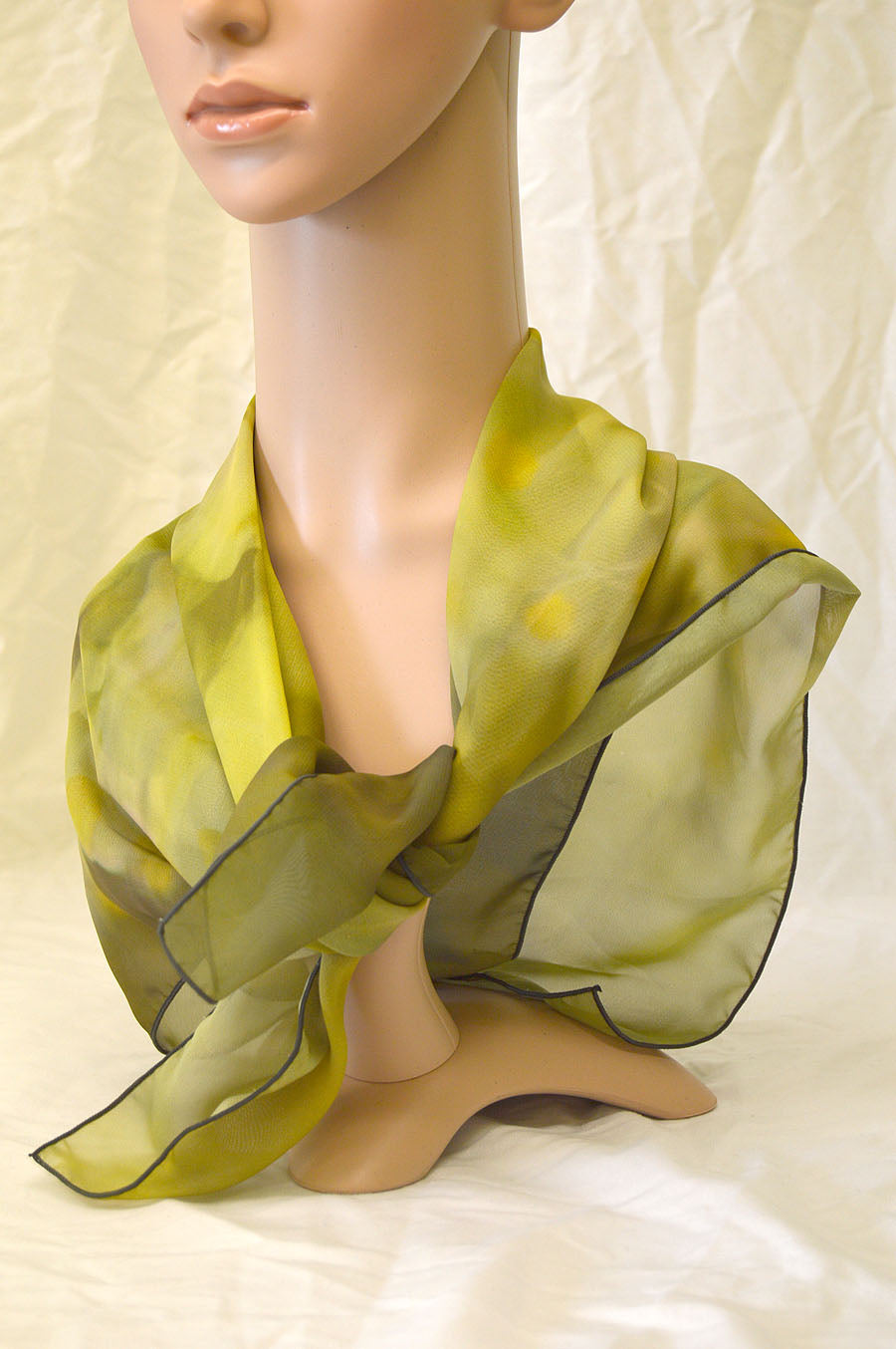 Photography by Rowena Trapp. The scarf is 100% polyester.  It is machine washable and dryable and measures 26x26. The image is a compilation of a yellow wildflower and autumn leaves blowing in the wind.  The image is printed on the front but shows through the sheer fabric.