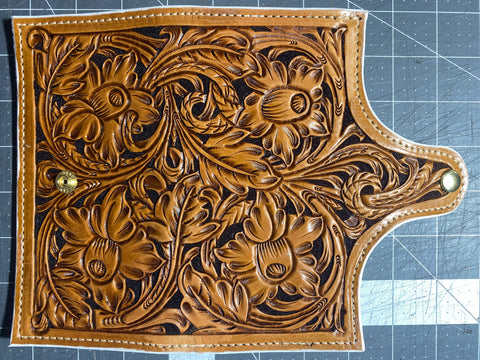 Hand tooled daffodil leather clutch. red and white interior leather. white dyed edged. snap closure. bill pockets and 5 card slots.