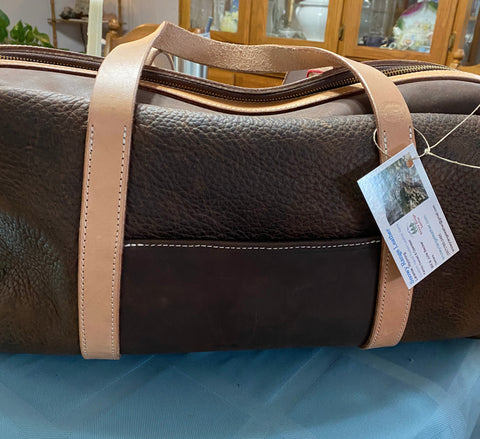 dark brown leather overnight bag. light brown leather handles.