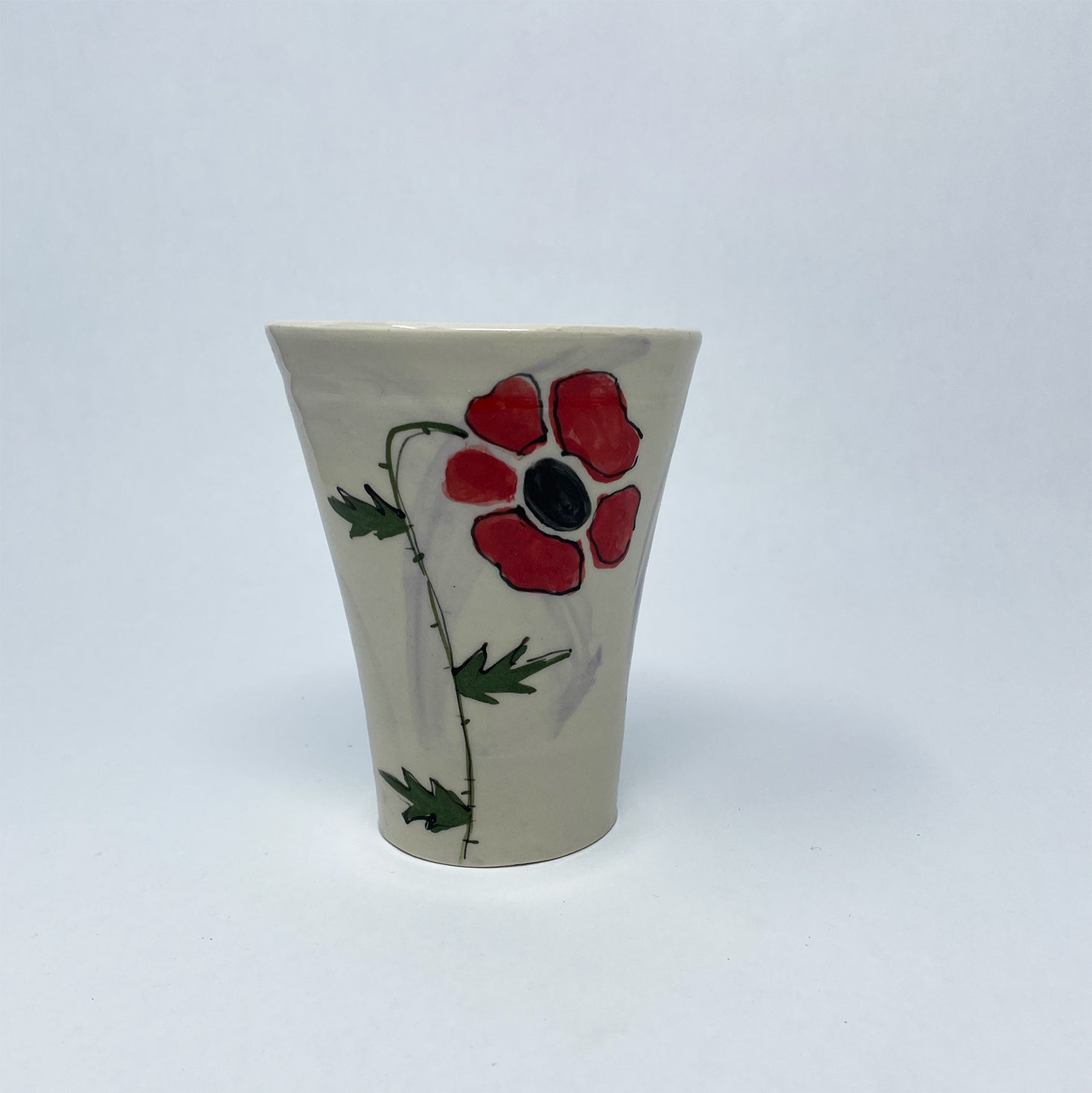 Handthrown, hand painted, porcelain tumbler with handpainted poppy flower and purple wash.
