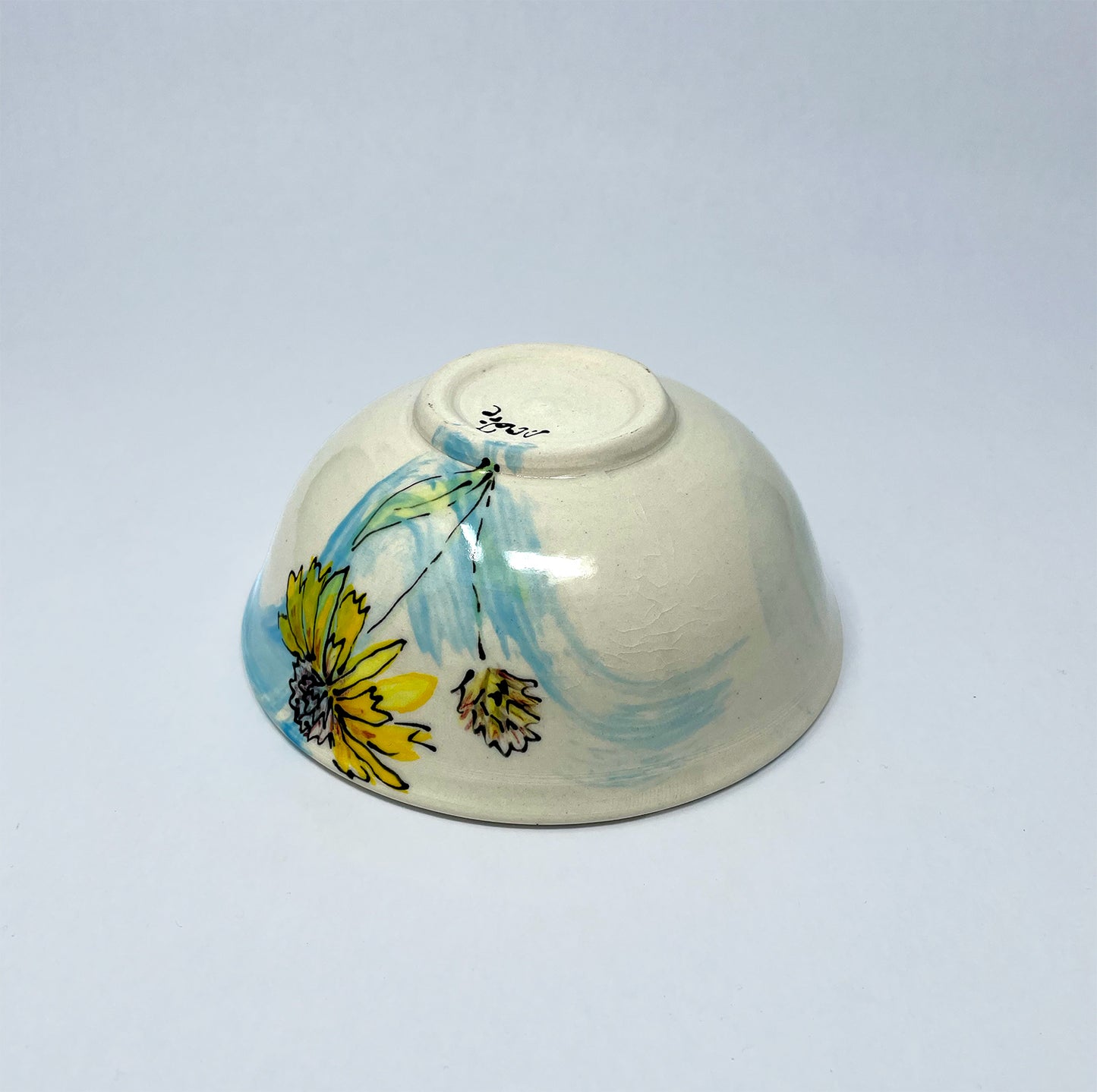 Bottom view of handthrown, hand painted procelain bowl of Wyoming Blanket Flower with a blue wash