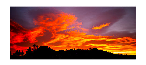 Photograph was taken in The Laramie Mountain Range located East of Laramie Wyoming  Looks like the clouds are on fire with the mountains in silhouette