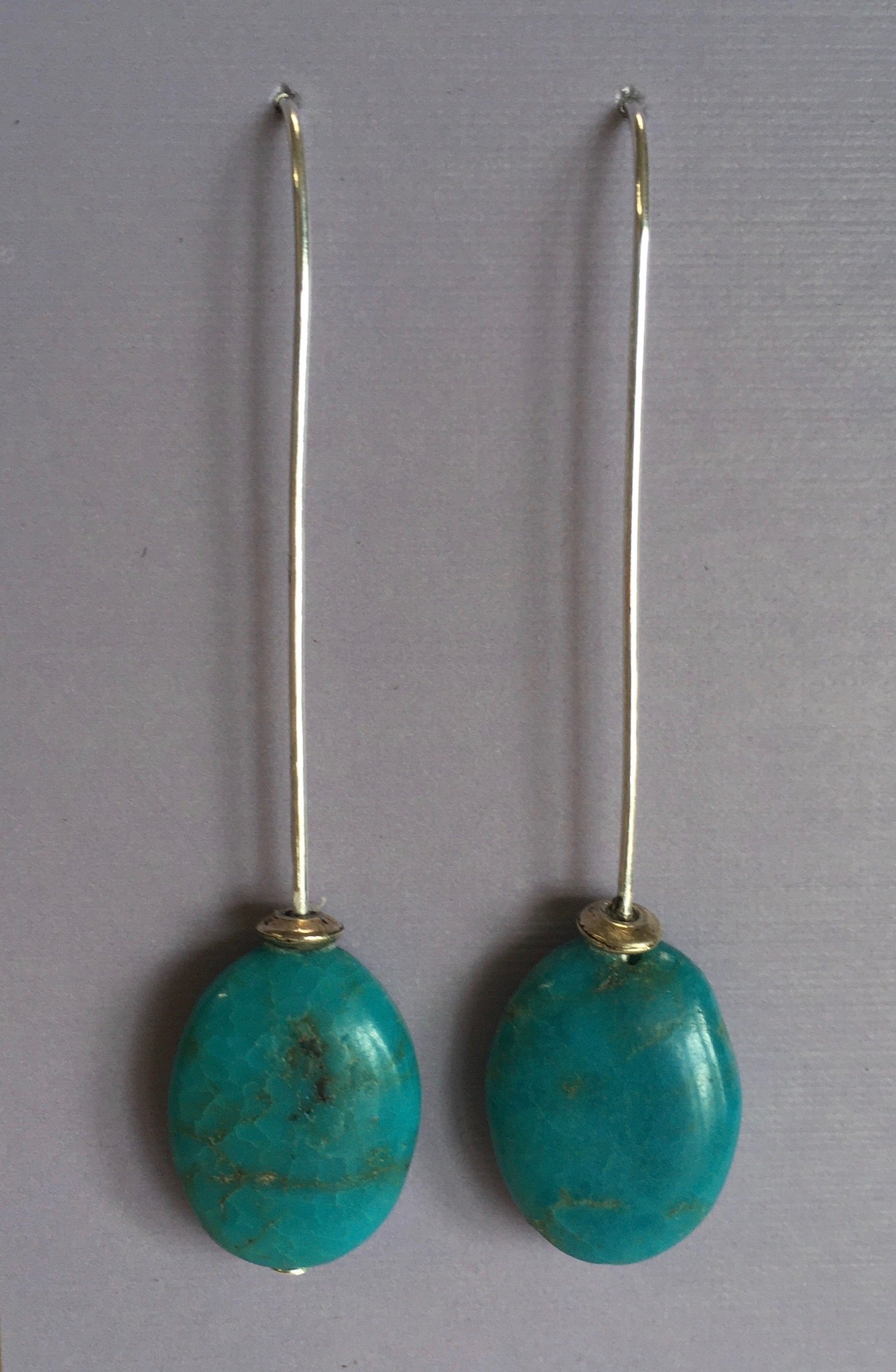 Oval Turquoise Long Drop Earrings Artist: Terry Kreuzer  5/8" X 1/2" oval turquoise  2" long including ear wires  Stirling Silver ear wires  Please note, the jewelry is custom designed by the Artist , with a slight variation between each piece