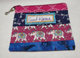 Good Karma Zipped Coin Purse Glenda Haley, Fabric/woodworker Artist Coin Purse is 5" x 1/8" x 3 3/4" Coin Purse has elephants/dragonfly pattern Coin purse zips Coin purse is cotton fiber Hand Wash Please note, the coin purses are a custom designed by the Artist , with a slight variation between each piece