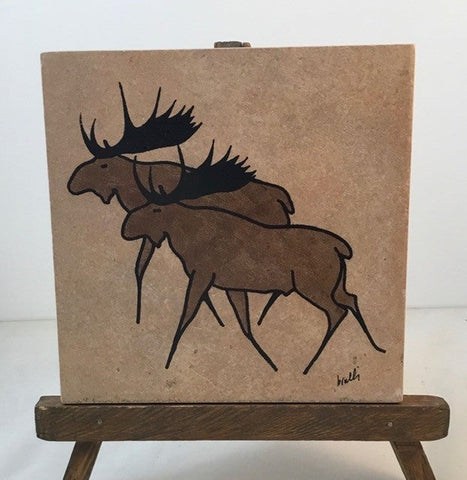 Moose Trivet Artist: Elizabeth Rulli A recycled trivet from Habitat for Humanity  Restore with a Indian Paintbrush hand paint on trivet  Wood bottom with felt pads on bottom coroners  Hand painted and fired to 1375 degrees and will clean with scouring power if a pan leaves a mark  Moose painted on each trivet