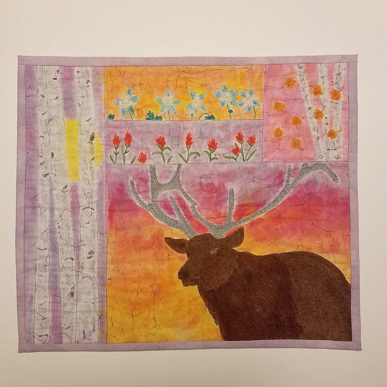 Fiber Art Wall Hanging " Elk " Artist: Crystal Lawrence Hand dyed and hand stitched fabric art piece  Wyoming wildflowers and Aspen trees come to life  Bull Elk standing in the sunset  25" long x 21" high  Wooden dowel with fabric slots on back of piece for hanging  A beautiful one of a kind piece of art that will become a family heirloom  Please note, each piece is a handmade and custom designed by the Artist   Location: CLL