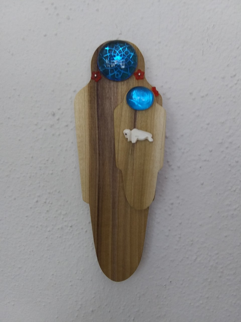 Wooden Spirit Shape of a Woman holding a Child  Mixed media  Wooden shape with glass stone and bone Buffalo  Made in the image of a mother and child  7 1/2" long x 3" wide x 1/2" deep  Wire attached on back for hanging