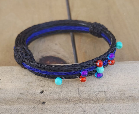 Hand Braided Horsehair Bracelet  Braided Black and dyed Blue horsehair  Small Teal, Red and Purple beads sewn into the braid  3/8" wide  Half hitched horsehair knot adjustment  Will adjust to fit most any wrist size